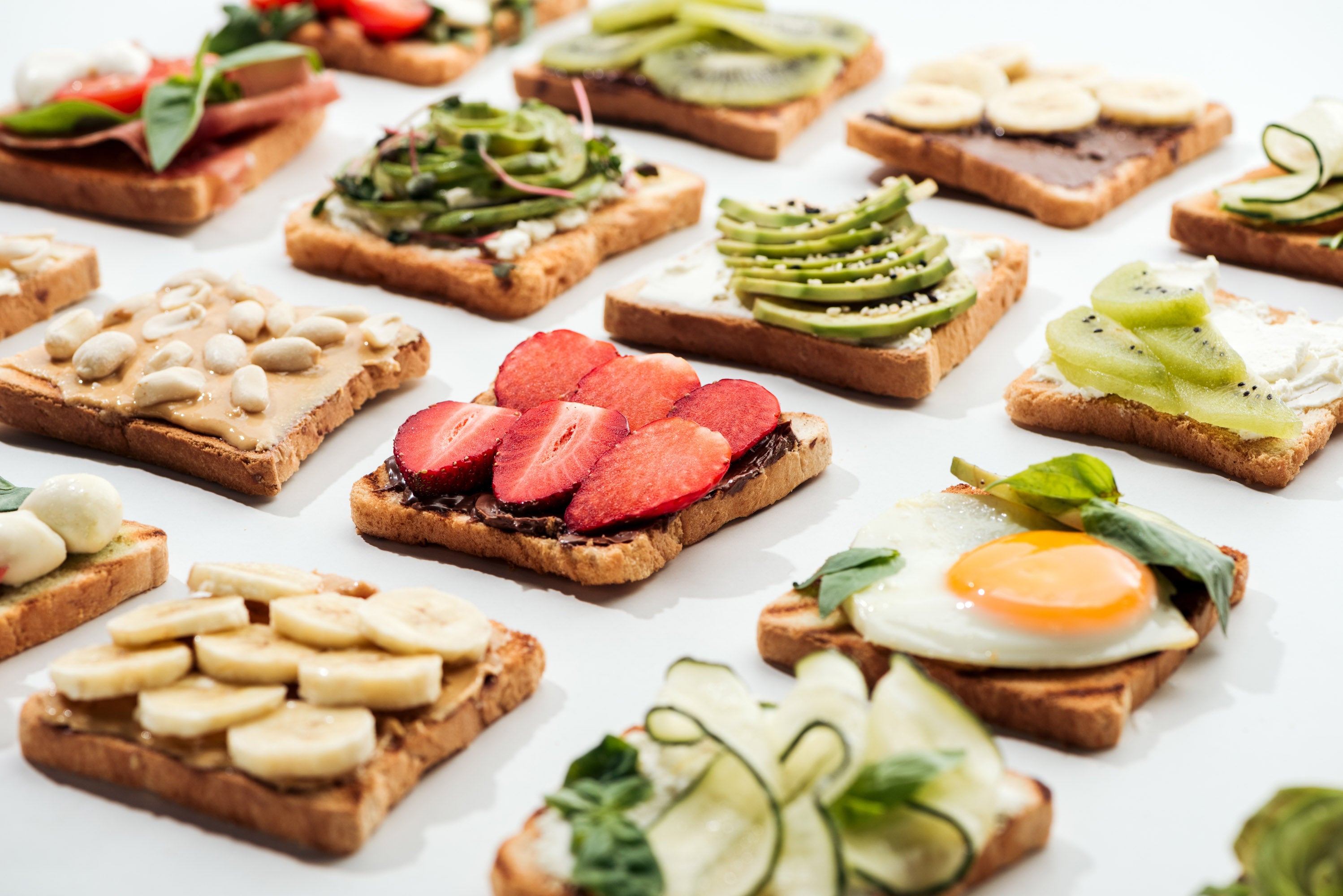 toasts-with-cut-fruits-fried-egg-and-peanuts-on-w-2024-11-09-04-27-25-utc.jpg